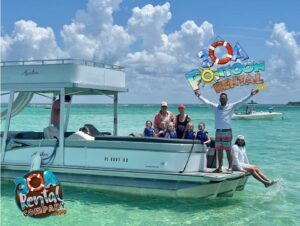 Group of people in life jackets sitting on a silver pontoon boat in clear turquoise water while a smiling man in striped shorts stands on the bow with arms raised, with “30A Pontoon Rental” branding over the bright, cloudy sky.